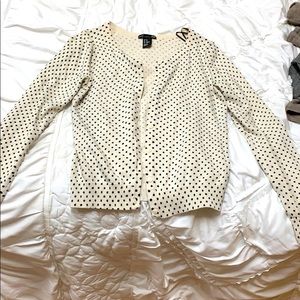 A cardigan with black polka dots on it